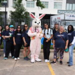 A group of volunteers standing with the Easter bunny.