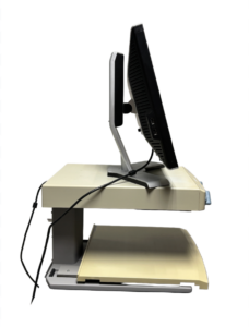 A dual monitor setup on a beige and gray stand with a keyboard tray underneath. The monitors are black with silver stands.
