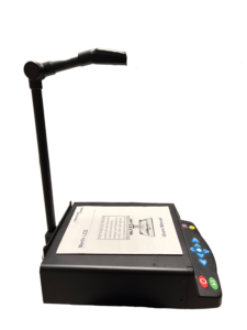 A SARA CE device with a users manual open on top, a camera on a stand above it, and control buttons on the front.